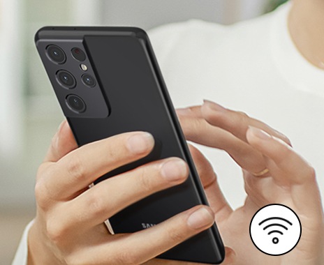 一個人正在透過智慧型手機和 SmartThings 智慧遠端控制管理冰箱。