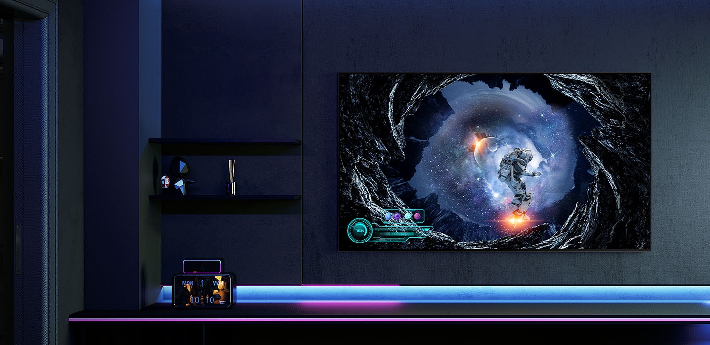 三星OLED在遊戲玩家的暗色調客廳中顯示出一款銀河遊戲，並有藍色和紫色的燈光照明。