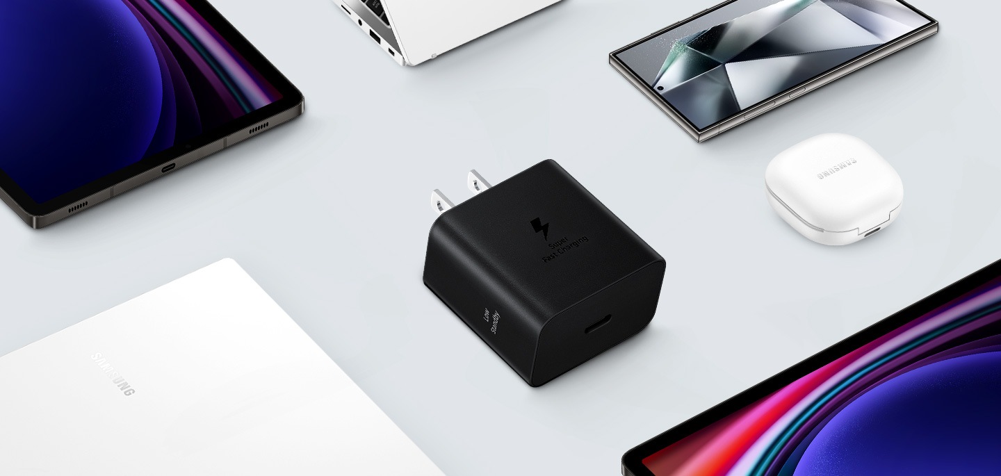 各種 Samsung Galaxy 裝置的俯視圖，中心為黑色快充旅充頭。左邊是 Galaxy Book3，右邊是白色 Galaxy Buds2 Pro、Galaxy Tab S9 和 Galaxy S24 Ultra。