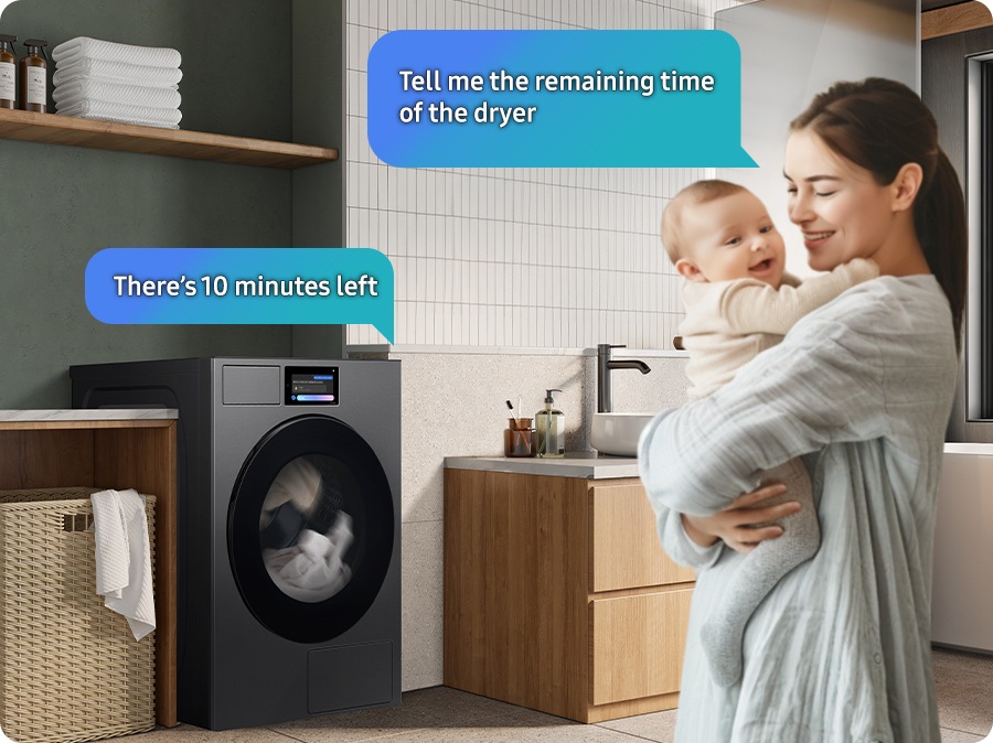  Bixby 語音控制功能展示：一位女士在洗衣房中抱著孩子，無需動手，直接透過 Bixby 語音詢問乾衣機剩餘時間，乾衣機直接聲音反饋「還剩下 10 分鐘」，展示其聽懂需求的智慧操作。