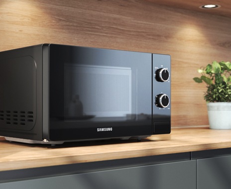 Shows the front of the microwave oven on a kitchen worktop with a full-sized glass panel that covers the whole door.