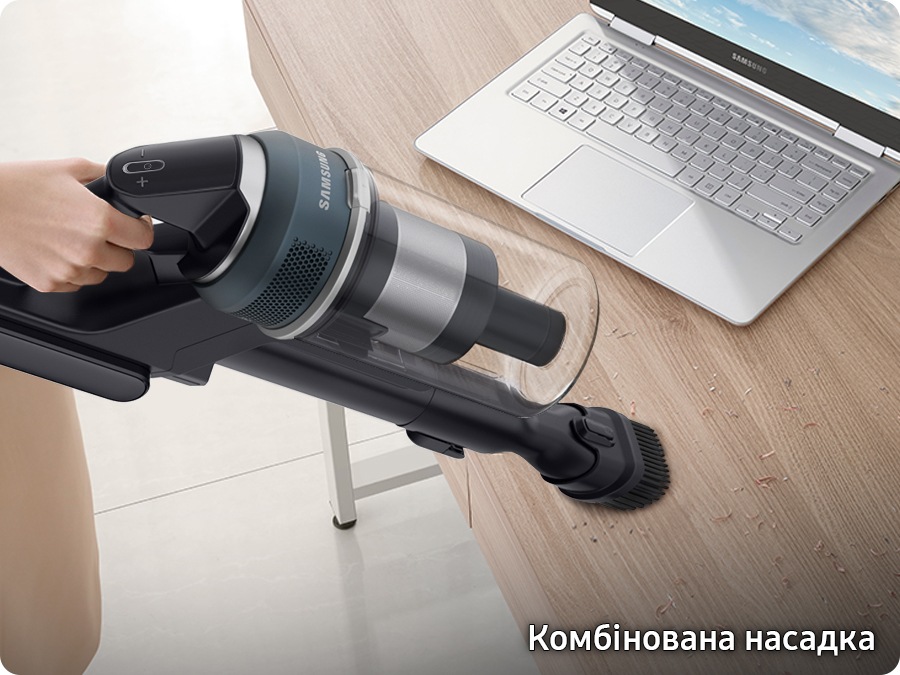 A Jet 85 with the combination tool cleans dirt on a desk near a laptop. 