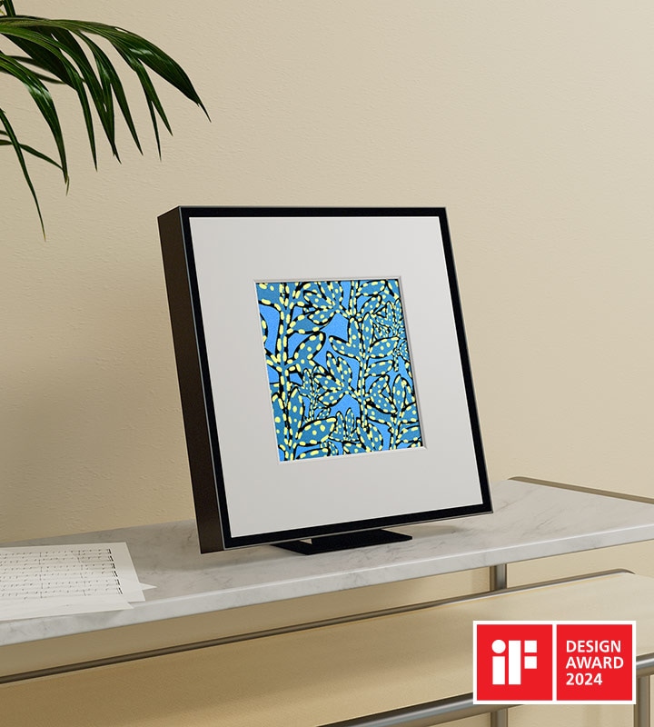 Music Frame displays an abstract blue vine pattern and is placed on top of a shelf. iF DESIGN AWARD 2024 logo.