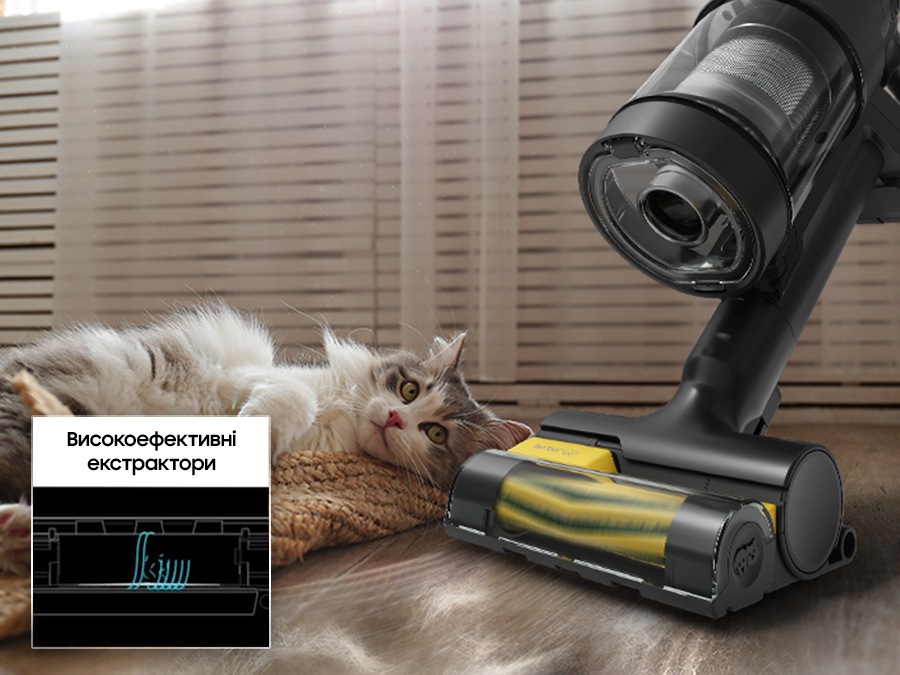 «Bespoke Jet AI Ultra» з Pet Tool+ очищає котячу шерсть на підлозі біля білого кота, який лежить на килимі. Гумова насадка та щетина щітки є високоефективними екстракторами, які всмоктують всю шерсть домашніх тварин. Він показує анімацію стрижки та смоктання шерсті домашніх тварин.