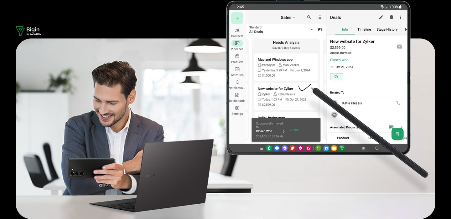 La aplicación Bigin está abierta en la pantalla principal del Galaxy Z Fold5. El diseño de la aplicación es espacioso en Multi View y muestra el menú y múltiples niveles de información en una sola pantalla. S Pen Fold Edition para Galaxy Z Fold5 se utiliza para realizar anotaciones en la aplicación. Un hombre sostiene un Galaxy Z Fold5 plegado y mira la pantalla de cubierta con una computadora portátil abierta frente a él. Logotipo de Bigin de Zoho CRM.