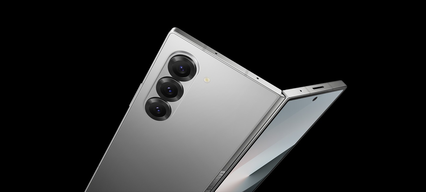 Se ve un Galaxy Z Fold6 ligeramente desplegado desde un ángulo inclinado, con tres lentes de cámara trasera a la vista.