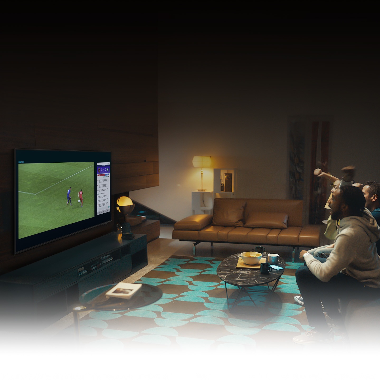Skupina ljudi uporablja funkcijo QLED TV Multi view za uživanje v nogometni tekmi in ogled informacij o igranju ob tekmi hkrati na istem zaslonu.