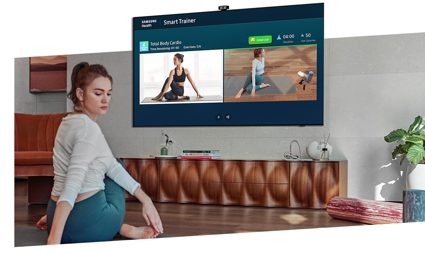 A woman exercises more accurately with QLED TV's camera-powered coaching feature which lets her watch herself and the training coach at the same time.