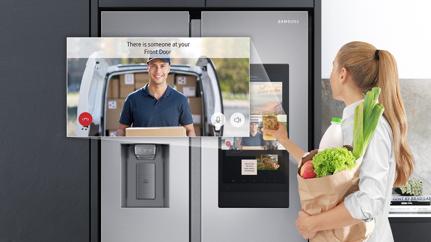 A woman holding lots of foods is confirming the arrival of the courier on the Family Hub screen.