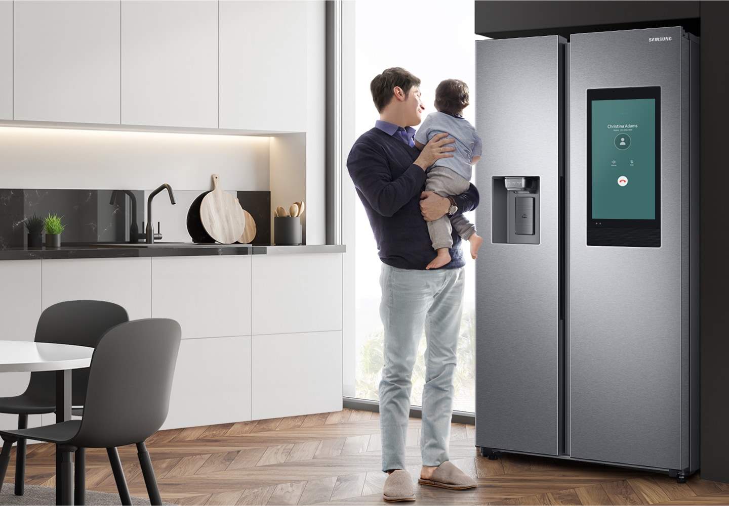 A man holding a baby in the kitchen is making a Bluetooth Call on the Family Hub screen.