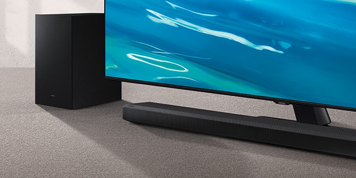 Samsung Global No.1 logo can be seen along with Samsung Q700A Soundbar and subwoofer which are positioned next to QLED TV.