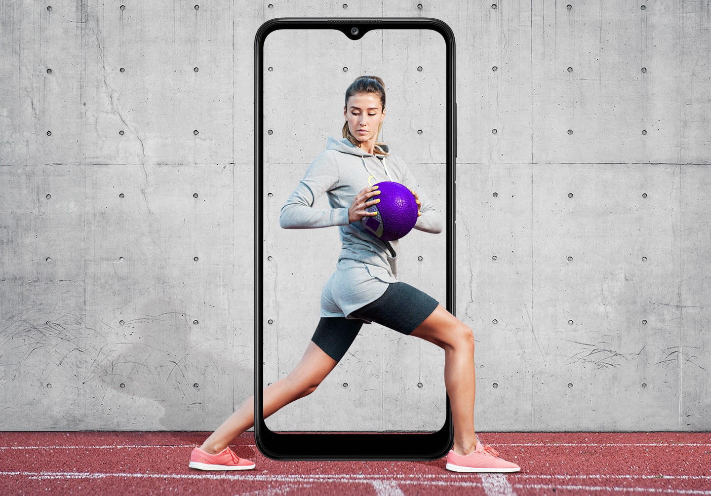 A woman is shown performing a standing torso twist with her legs in a lunge position while holding a purple medicine ball. The Galaxy A03s's slim bezel frames her entire body, with her feet and part of her calf outside it.