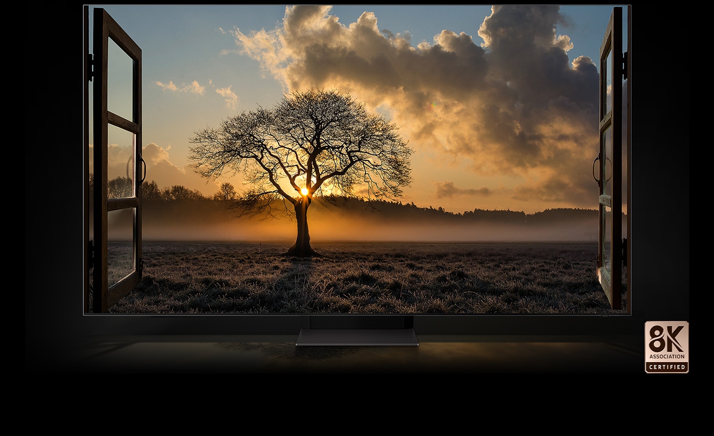 The sun sets and there is a thin tree in a wide field. QLED 8K TV is certified by the 8K Association.