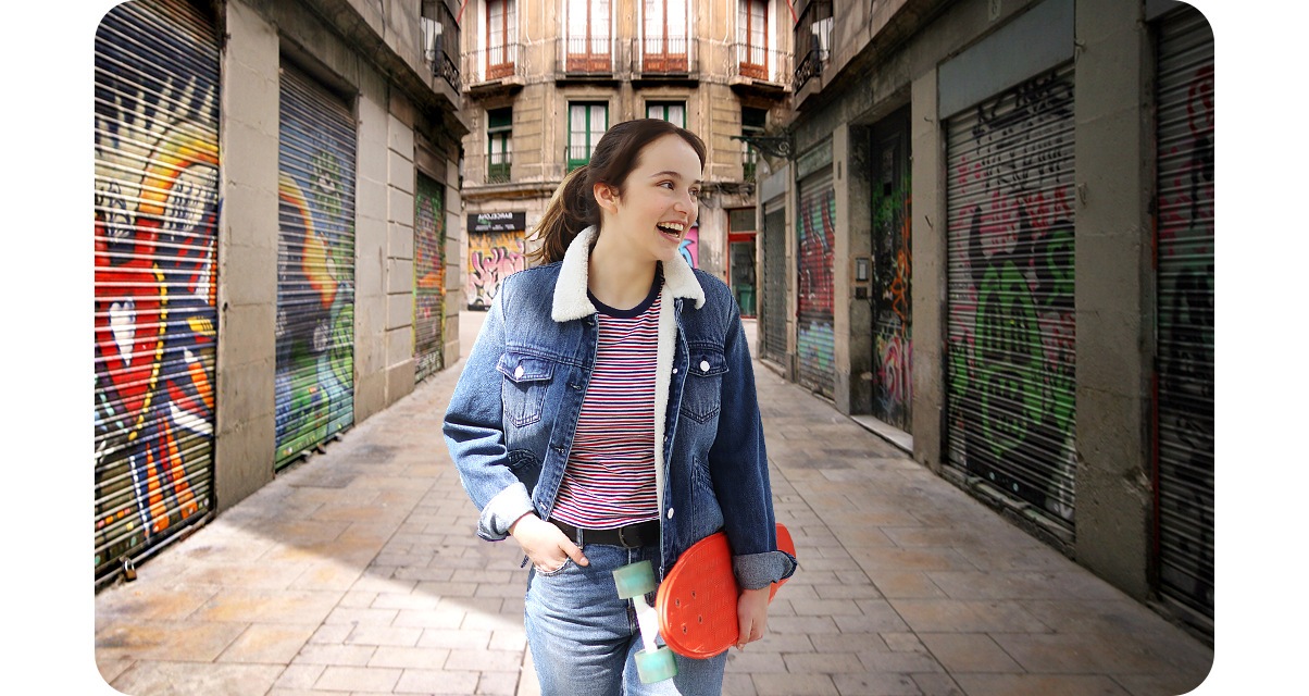 2. A woman is standing in front of an alleyway painted with colorful graffiti. With the Portrait Off icon above activated, the background is clear and portrays both the woman and the alleyway accurately.