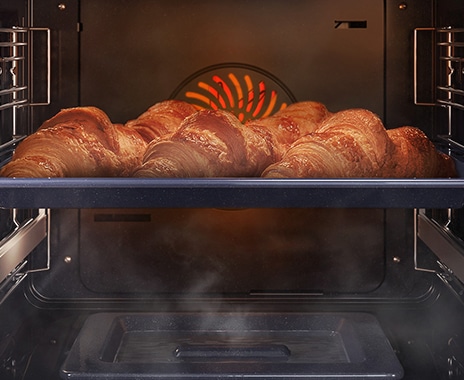 Shows a close-up of croissants being baked in the oven, but being kept moist with steam using the Natural Steam option.