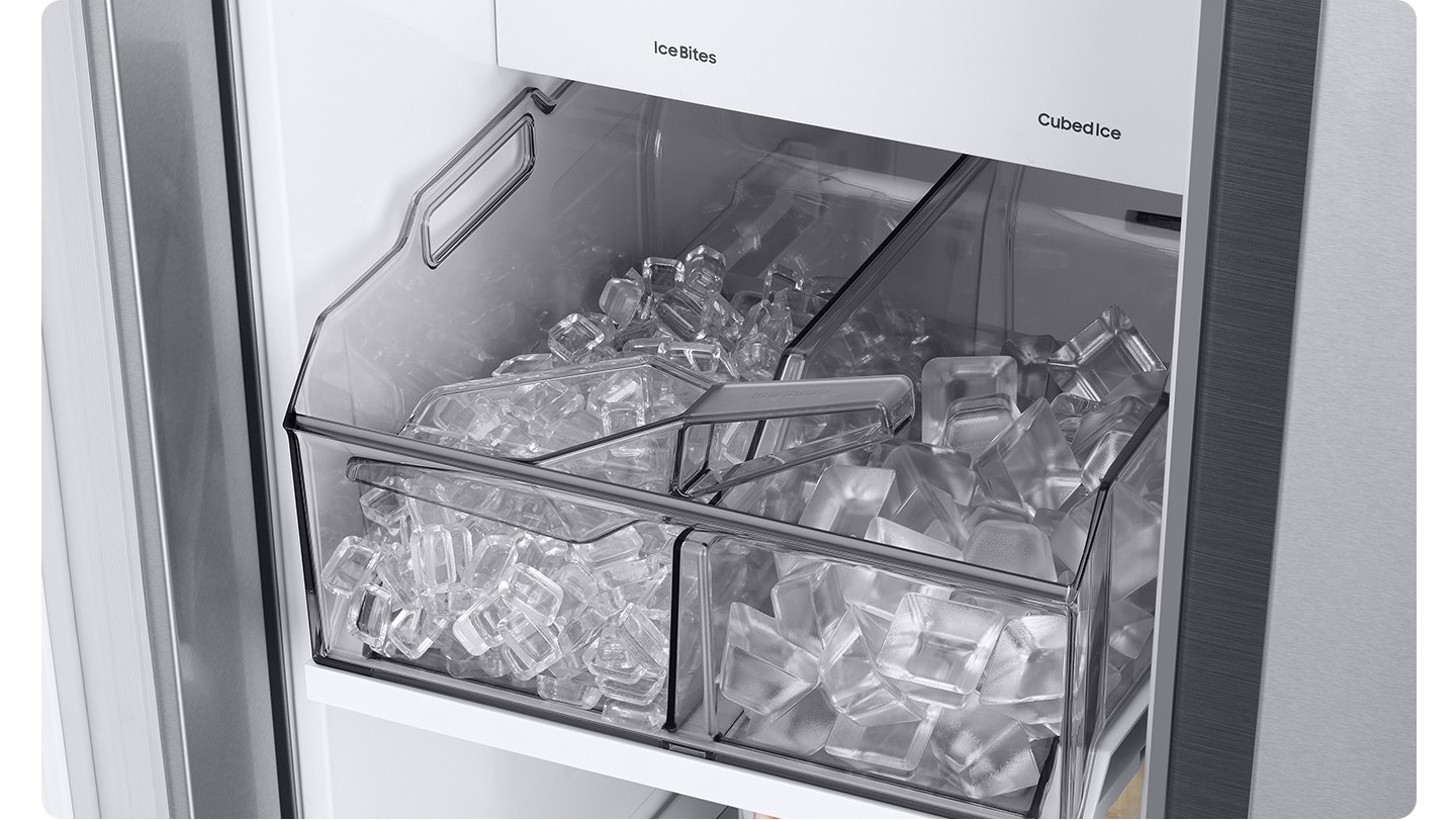 The dual tray in the freezer is full of ice. The left tray is full of large ice cubes and the right tray is full of small ice cubes.