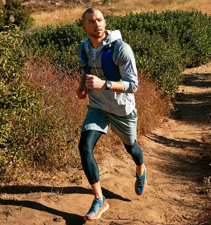 A man hiking downhill with a Watch5 Pro on his wrist displaying the navigation feature.