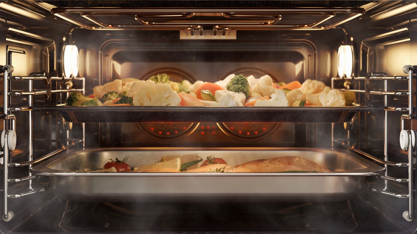 Afișează o tavă cu legume în zona superioară și un preparat de pește în zona inferioară, care sunt gătite folosind sistemul de convecție, dar cu abur adăugat.
