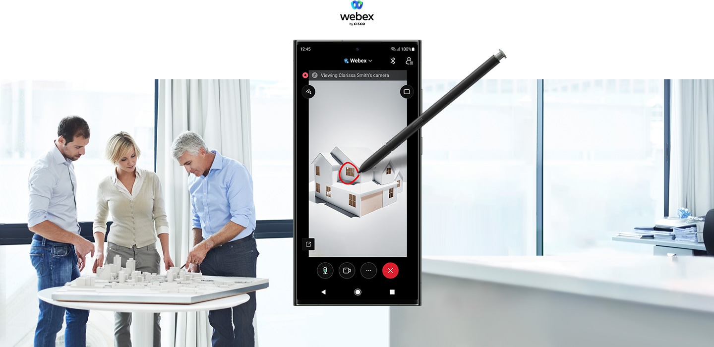 Galaxy S23 Ultra con la aplicación Webex abierta en su pantalla. Un S Pen dibuja una representación arquitectónica en 3D de una casa al mismo tiempo que se realiza una videollamada. Los controles de videollamadas están en la parte inferior de la pantalla. Junto al aparato, tres ingenieros inspeccionan un modelo urbanístico en miniatura.