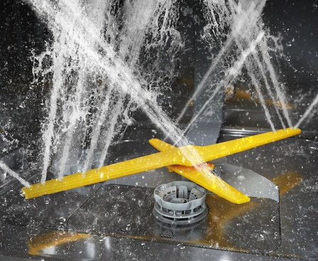 Shows the rotating dual wash arms of the WaterJet Clean™ system spraying powerful jets of water in multiple directions.