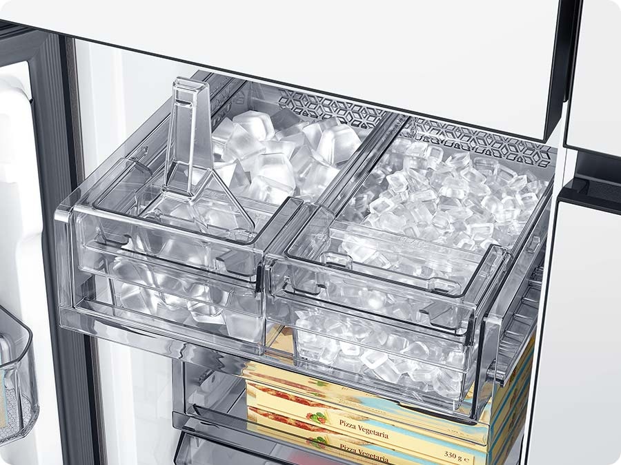 The dual tray in the freezer has ice. The left tray is full of cubed ice and the right tray has ice bites.