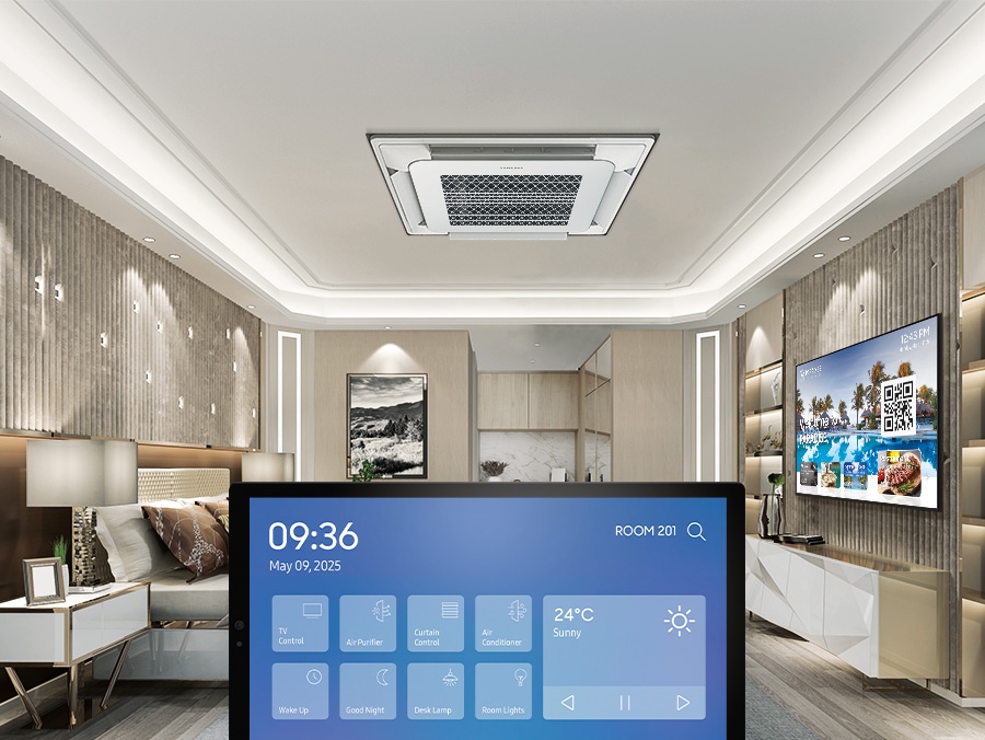 In a hotel room with Hotel TVs mounted on the wall, a tablet is prominently displayed in the center. The tablet screen shows the UI of Smart Things Pro.