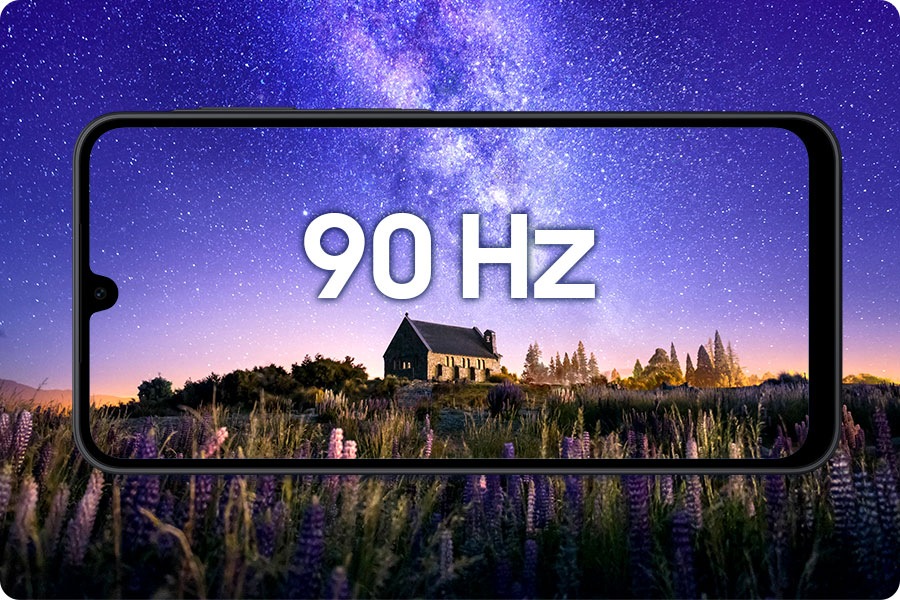 A horizontal view of a black-framed Galaxy A17 smartphone showing a night scene in the background: a stone cottage surrounded by purple flowers under a starry violet-blue sky. '90 Hz' text is centered on the screen, highlighting the display’s smooth motion.