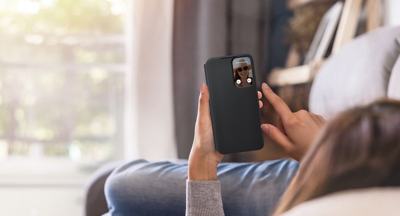 Person lying on a sofa using the phone window on the front of the phone case without having to open the case
