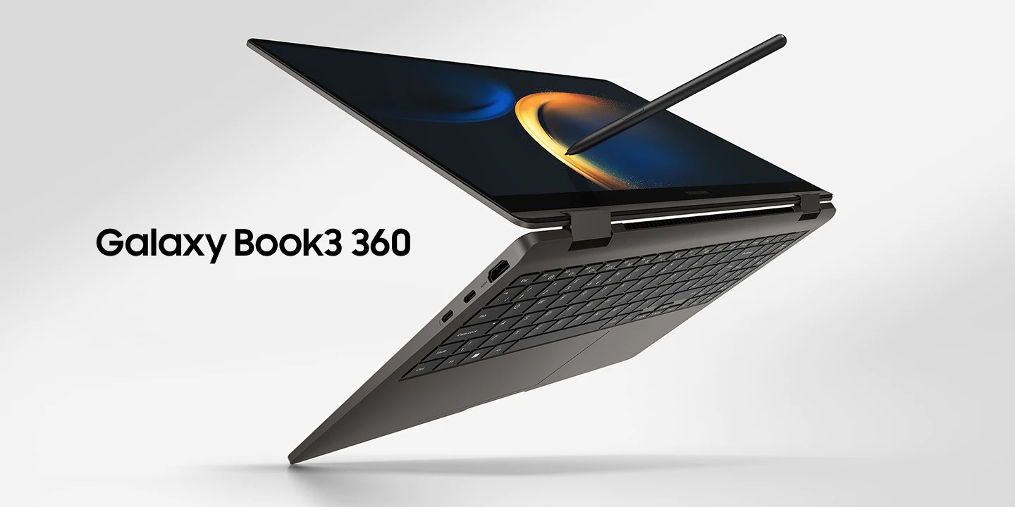 A graphite-colored Galaxy Book3 360 is folded slightly back, facing left with a black wallpaper onscreen and an S Pen placed next to it.
