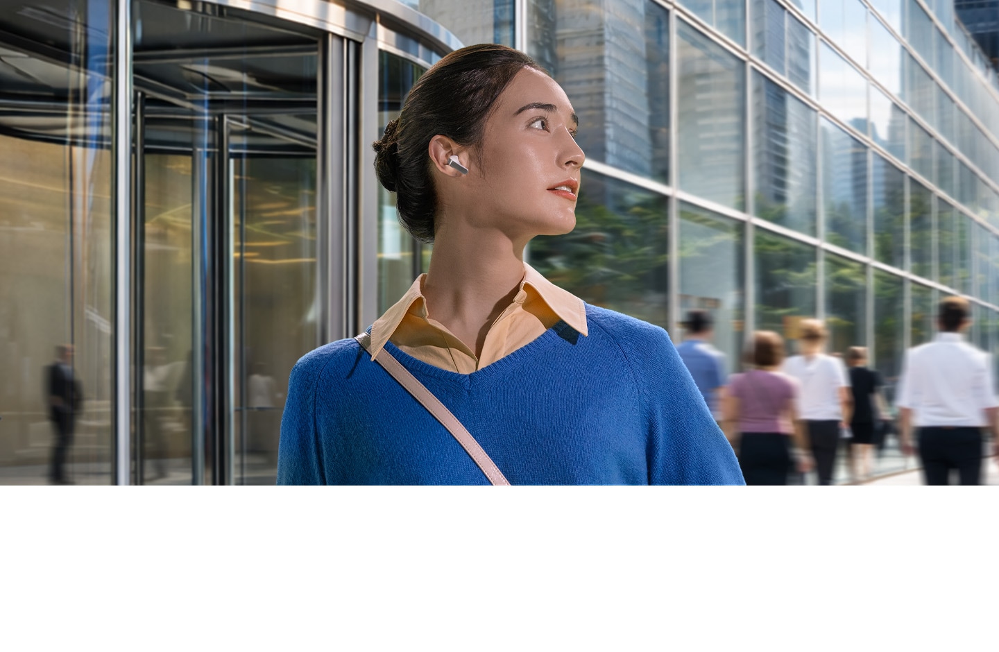 A woman with a single, white Galaxy Buds4 earbud in her ear looking towards the right in front of a building.