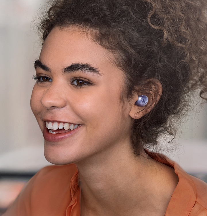 Une femme portant des Galaxy Buds Pro dans un café.