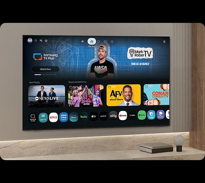 TV in a living room shows Samsung TV Plus home screen and the diverse TV channels available with it.