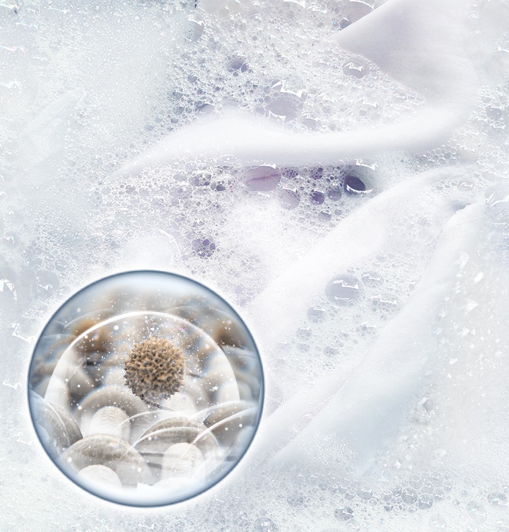 Laundry is soaked in bubbles. Stains are removed with the bubbles in close-up.