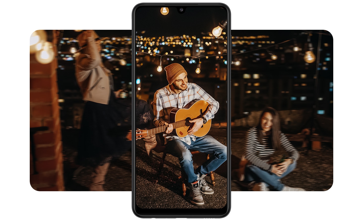 Mọi người thưởng thức bữa tiệc vào ban đêm với cảnh nền thành phố lấp lánh. Ở giữa là điện thoại Galaxy A22 quay dọc ghi hình một người đàn ông đang chơi guitar