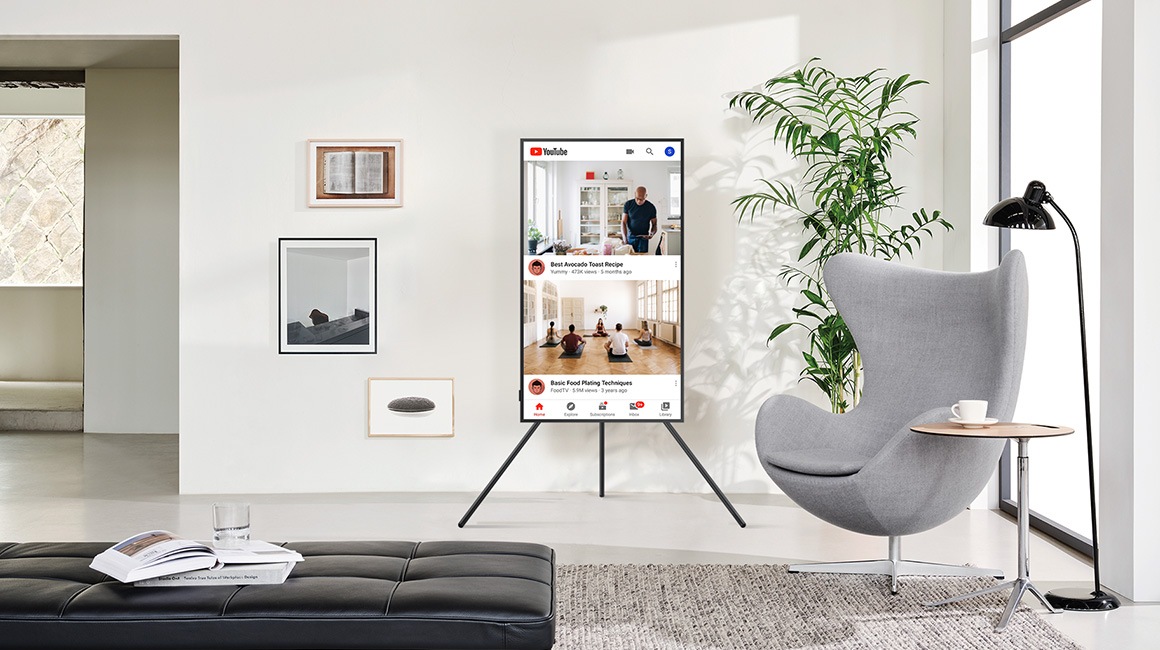 TV on Stand next to sofa.