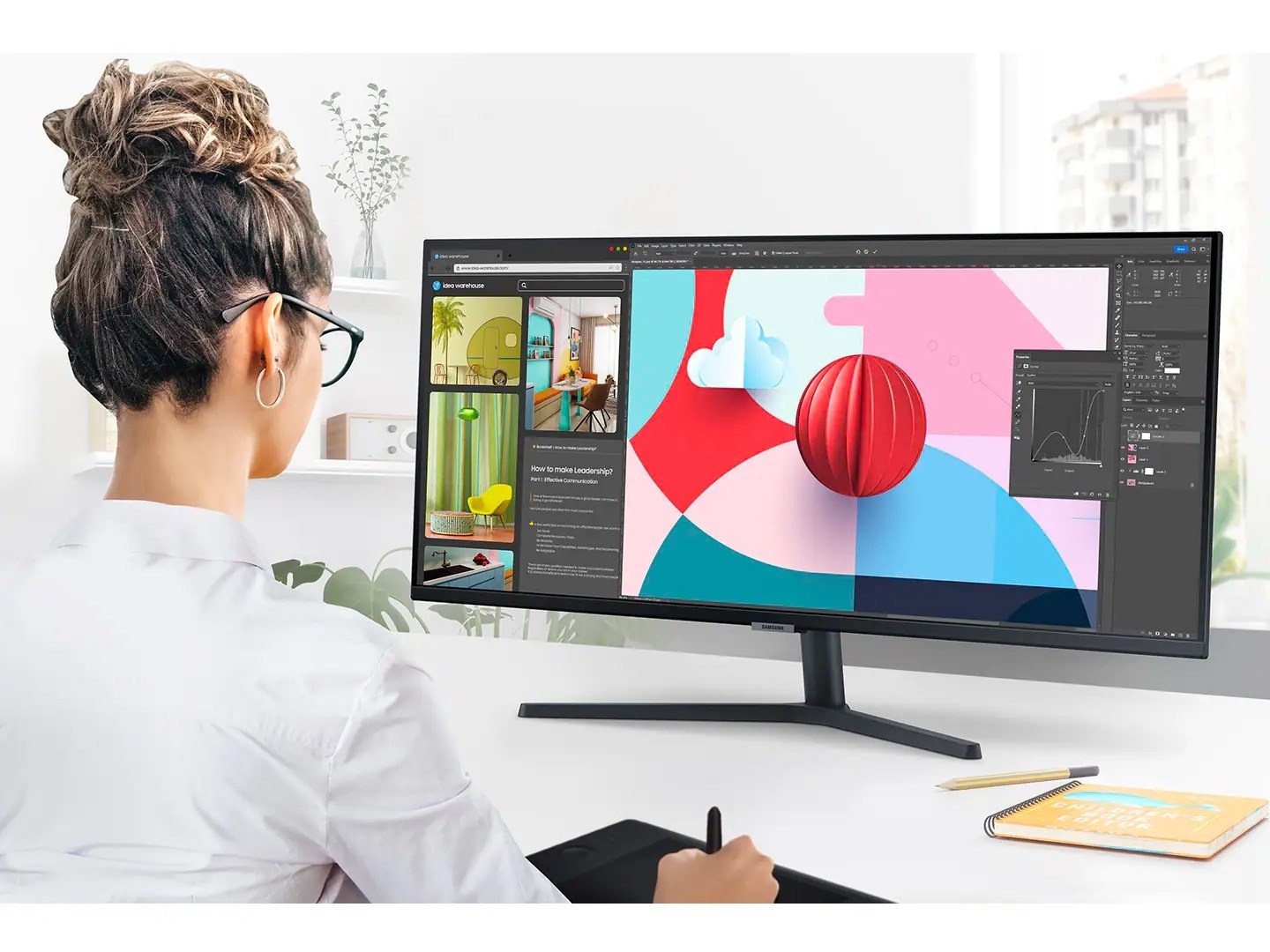 S50GC monitor on a desk is displaying a design software program across the wide display. The individual using the monitor is also using a digital drawing pad while working on the design project.