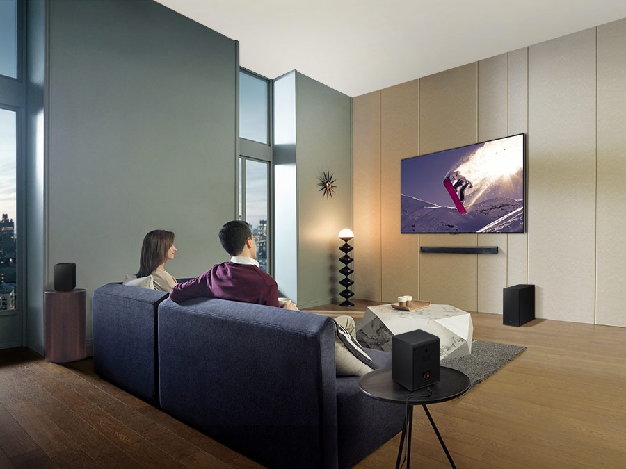 Family watches animation in immersive surround sound with Samsung Wireless Rear Speaker Kit and Soundbar activated together.