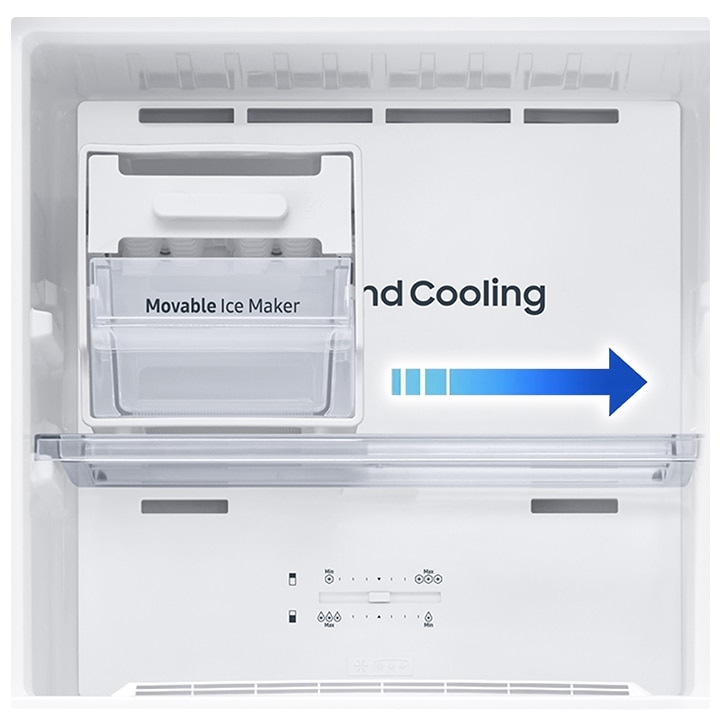 Close up of Auto Ice Maker. Ice cubes is full in the bin below and the cold air flows around.