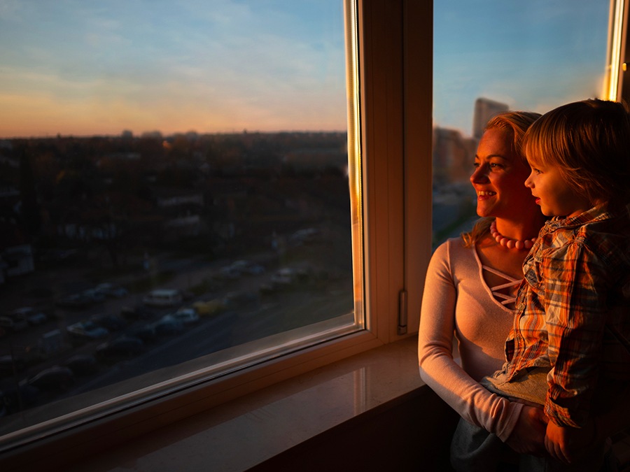 A camera view with the object eraser feature shows a mother and a son looking out the window at sunset. AI Edit is applied and as the scroll moves from left to right, the reflection of the mother and son on the window is removed. 