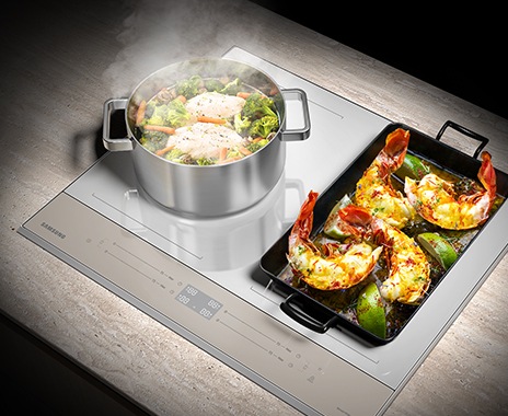 Hình ảnh một nồi ức gà và rau củ được nấu ở Vùng Flex Zone bên trái, và chảo lớn với tôm hùm được nướng ở Vùng Flex Zone bên phải.