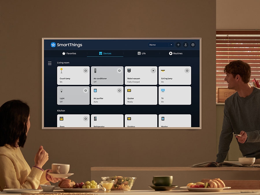 TV hiển thị SmartThings với nhiều thiết bị "Phòng khách" và "Nhà bếp" khác nhau được kết nối với trung tâm tích hợp.