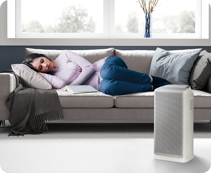 Một người đang ngủ trưa rất yên bình trên ghế sofa, bên cạnh cô ấy là chiếc AX5500 đang hoạt động nhẹ nhàng ở chế độ ngủ.