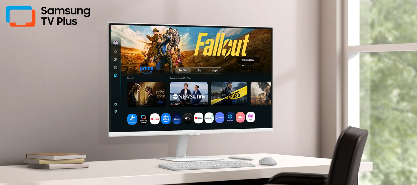 Màn hình trên bàn làm việc hiển thị trang Ứng dụng Smart TV với đa dạng nội dung và ứng dụng được sắp xếp trực quan. Logo Samsung TV Plus nổi bật.