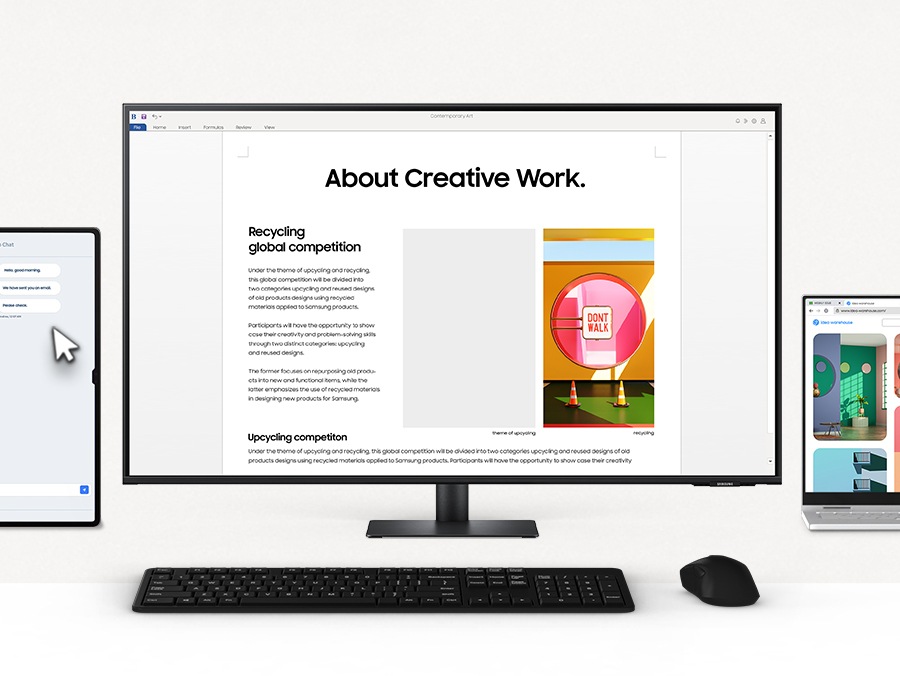Có một màn hình ở giữa, với một chiếc laptop và một máy tính bảng xung quanh. Tất cả các thiết bị được điều khiển bằng một con chuột. Con trỏ chọn một hình ảnh từ laptop và kéo và thả nó vào một tệp đang mở trên màn hình.