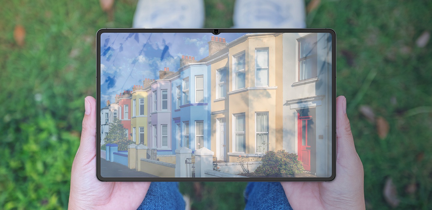 Một người ngồi trên cỏ, đặt thiết bị Galaxy Tab S11 lên đầu gối. Ánh sáng mặt trời phản chiếu trên màn hình khi không có Miếng dán bảo vệ màn hình chống phản chiếu, khiến nội dung trên màn hình khó nhìn.