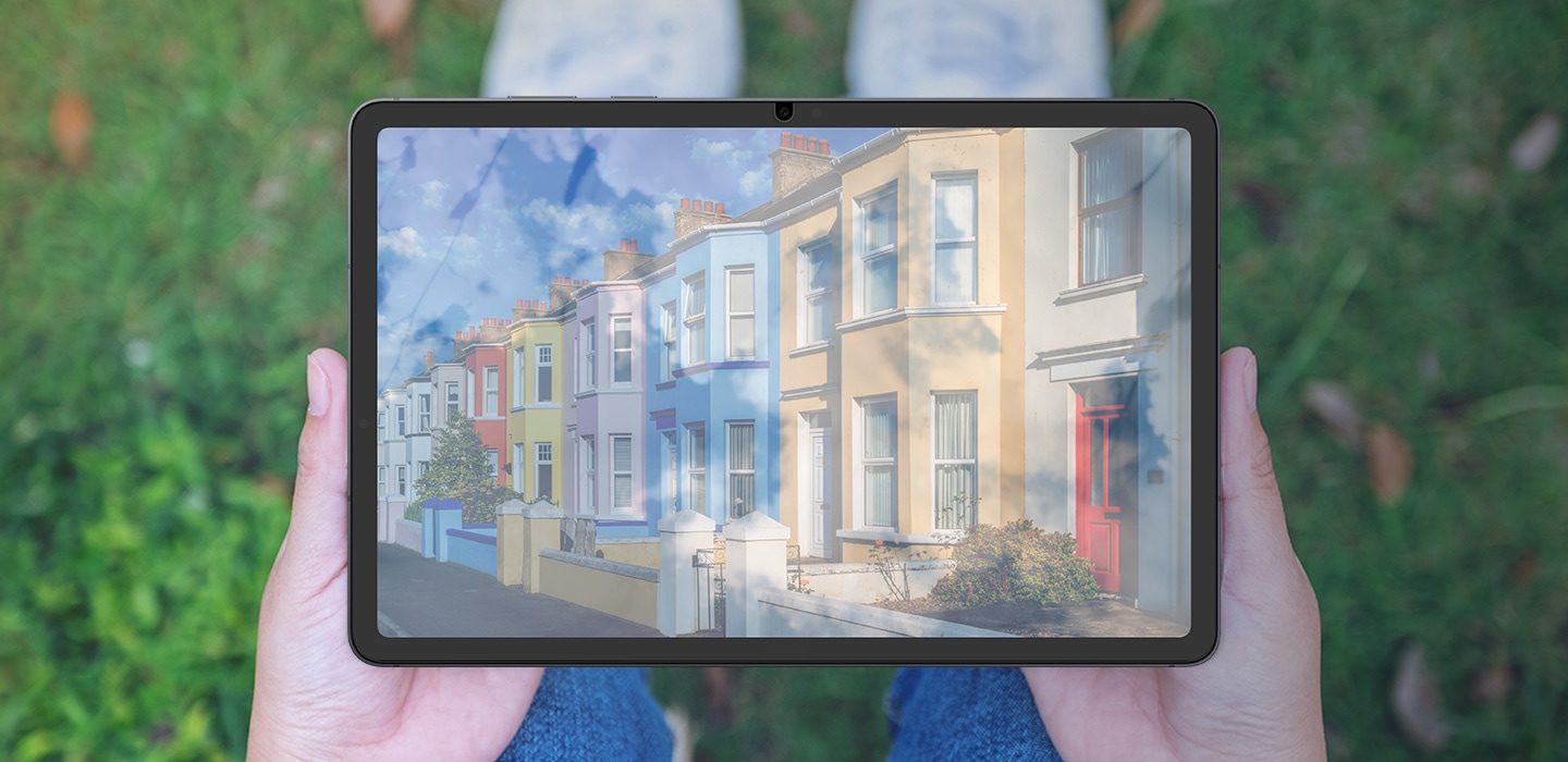 Một người ngồi trên cỏ, đặt thiết bị Galaxy Tab S11 lên đầu gối. Ánh sáng mặt trời phản chiếu trên màn hình khi không có Miếng dán bảo vệ màn hình chống phản chiếu, khiến nội dung trên màn hình khó nhìn.