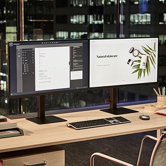 There are two ViewFInity monitors on a desk, and a document and a web browser are displayed on the monitor screens.