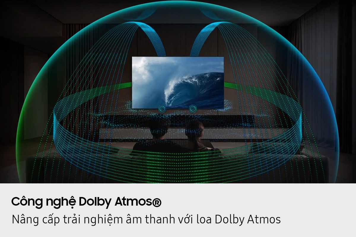 In a living room, a couple sits on a sofa and watches TV. The TV’s front speakers are lit up and soundwaves emanate from a TV’s speakers, travelling in multiple directions to surround the couple in a dome of sound and fill the room. Dolby Atmos logo.