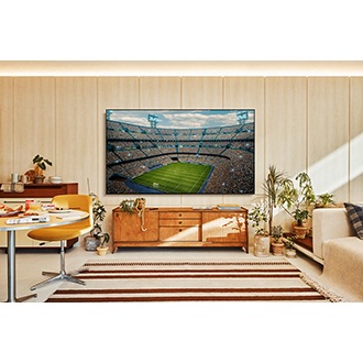 A U8000F is installed on the wall of a living room. It depicts a scene of a crowded stadium in vivid colors.
