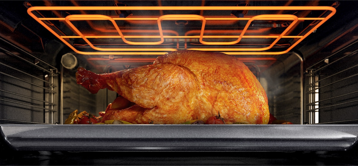 Shows the inside of the oven with the Power Grill Heater browning a large dish like chicken.